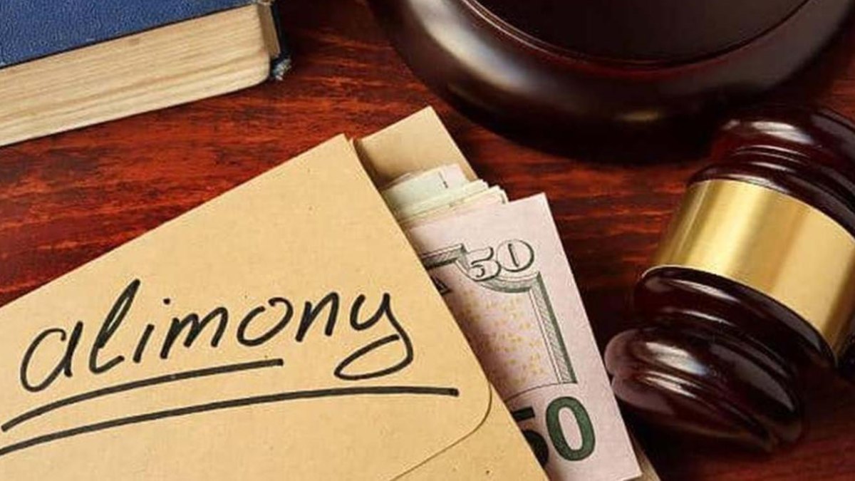 An envelope marked alimony with banknotes next to a judge's gavel